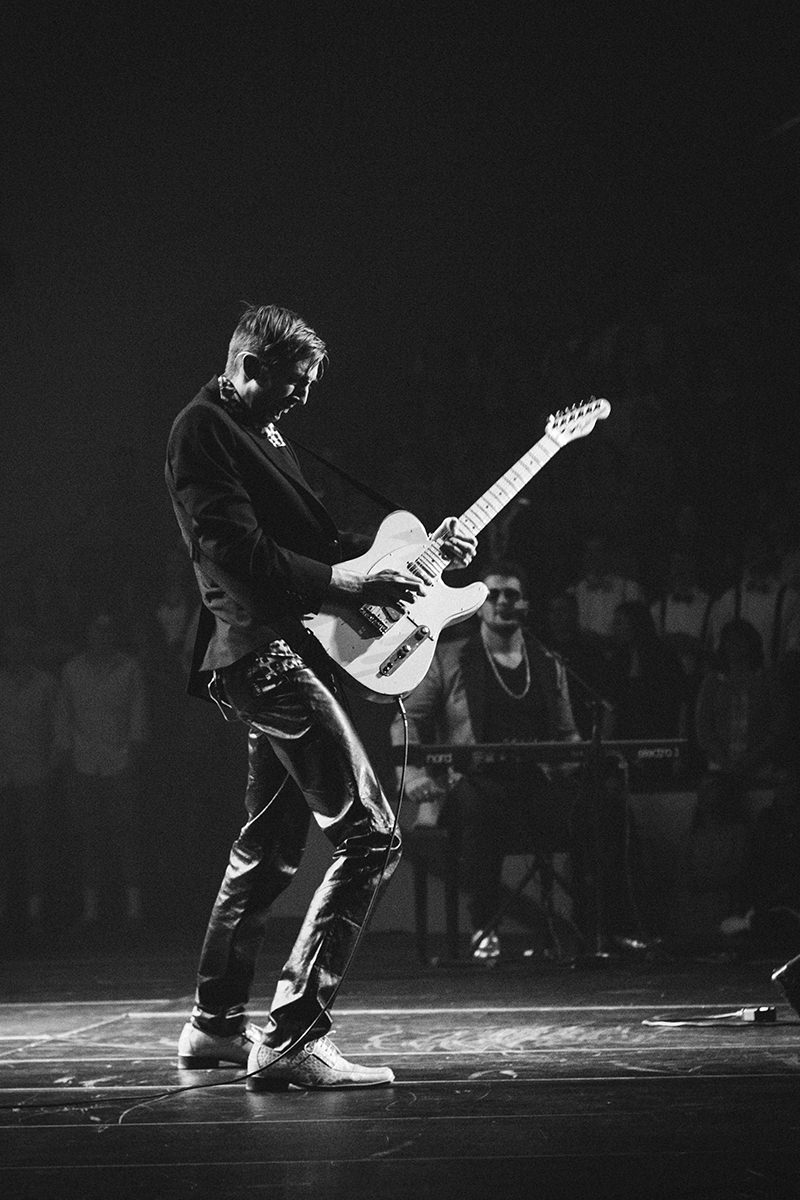 Serveis Audiovisuals Replay: foto d'un guitarrista sobre l'escenari concentrat tocant la guitarra.